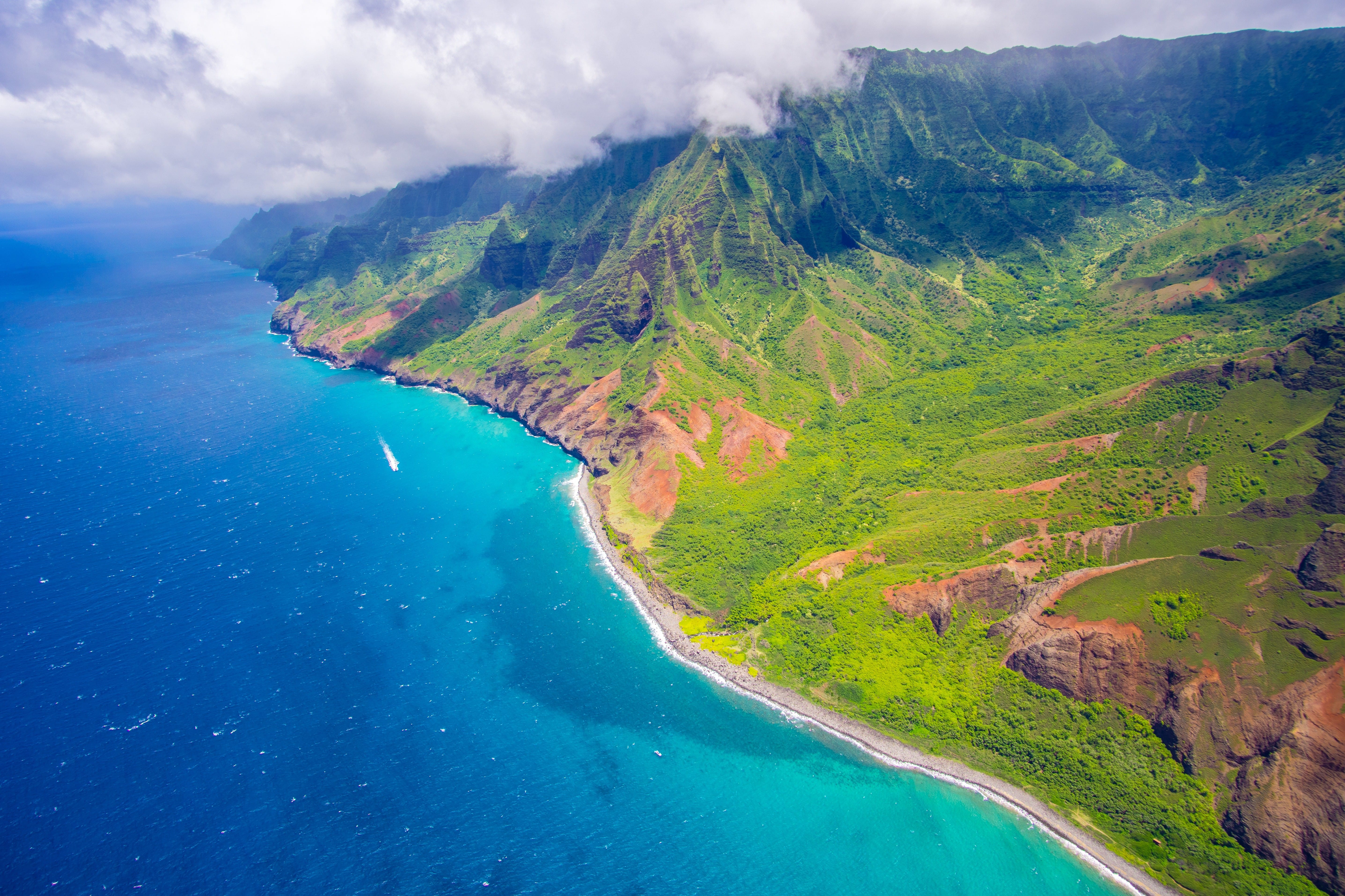 Behold the majestic green cliffs of Hawaii, where nature's artistry unfolds in vibrant hues. Plan your Hawaiian getaway with DREW Travel.