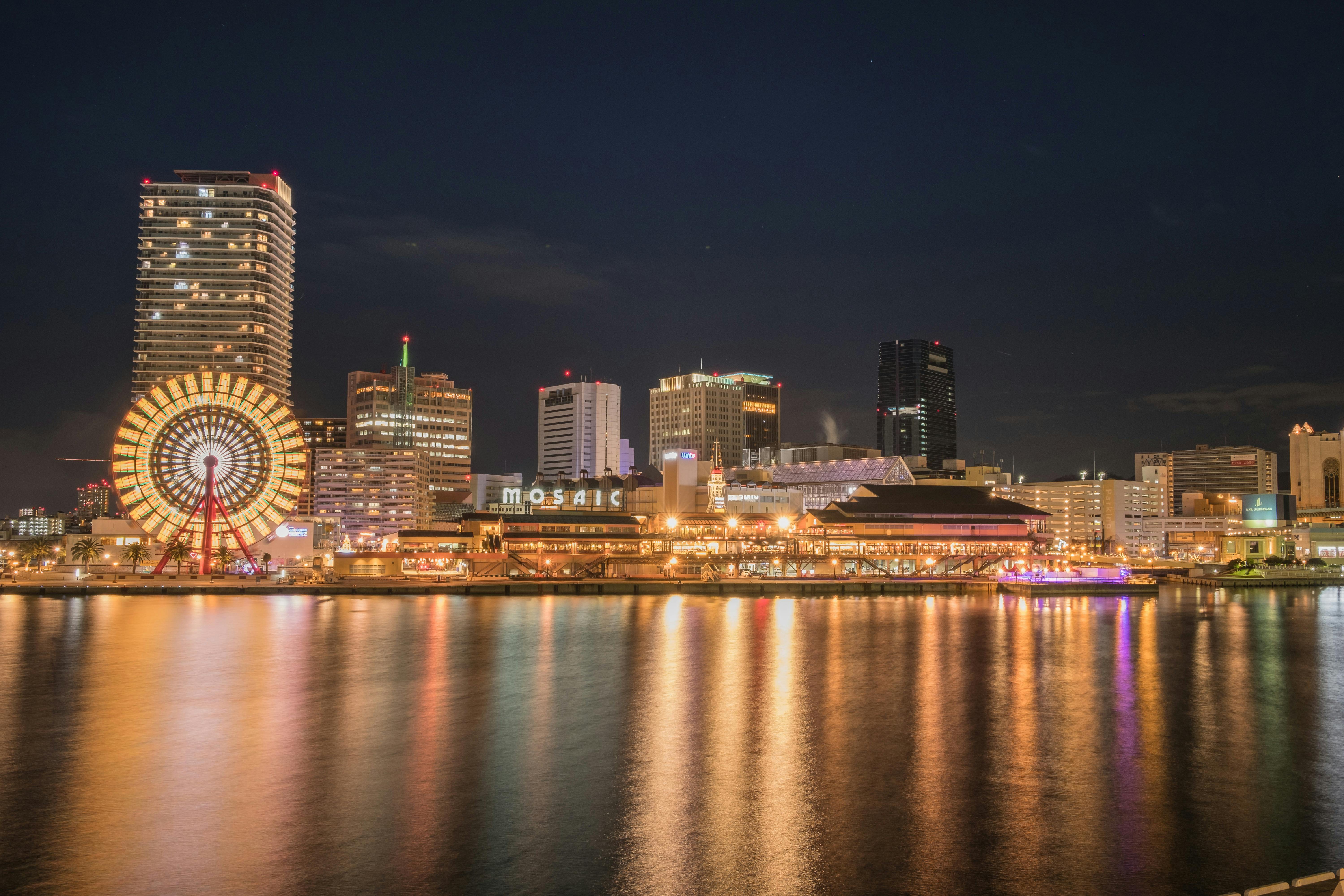 Experience the mesmerizing lights of Japan's cityscape reflected in the tranquil nighttime waters.